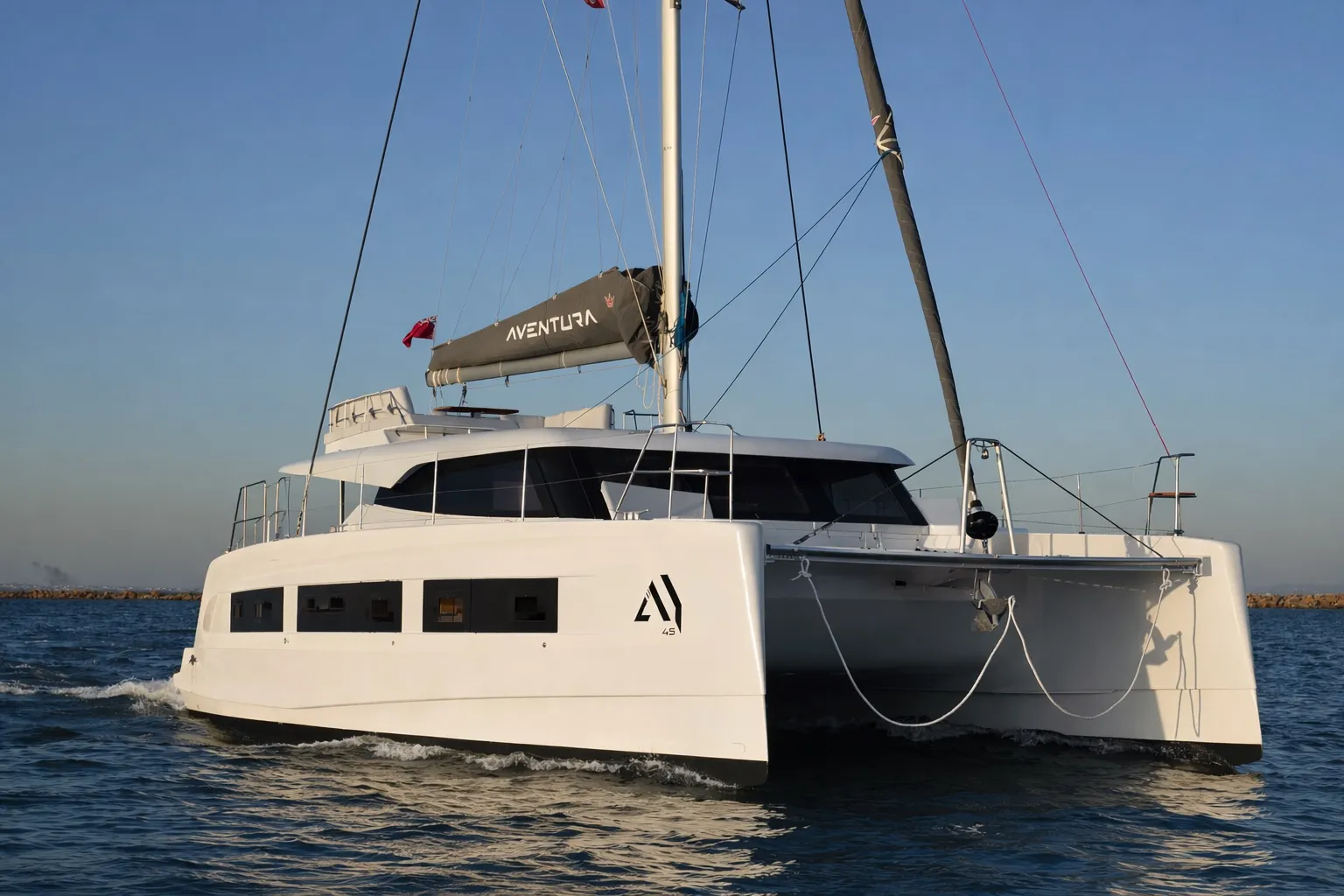 The Aventura 45 from the bow quarter, white hulls and a dark flybridge bimini